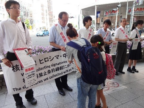  2017年7月：街頭で署名活動をする松井会長と高校生たち